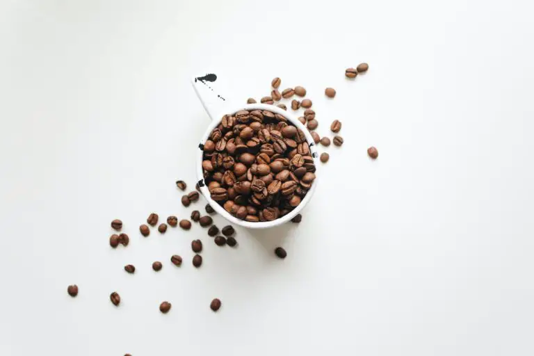 White Ceramic Mug Full Of Coffee Beans